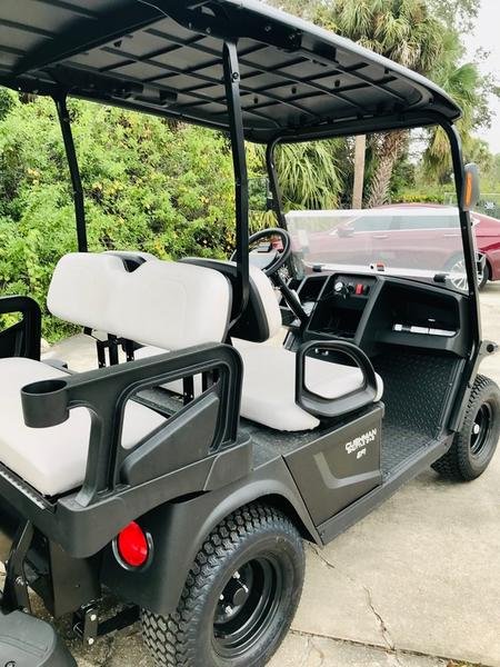 Autobús Cushman Shuttle 2+2 Gas 2024 operando a través de los terrenos del Belle Meade Country Club.